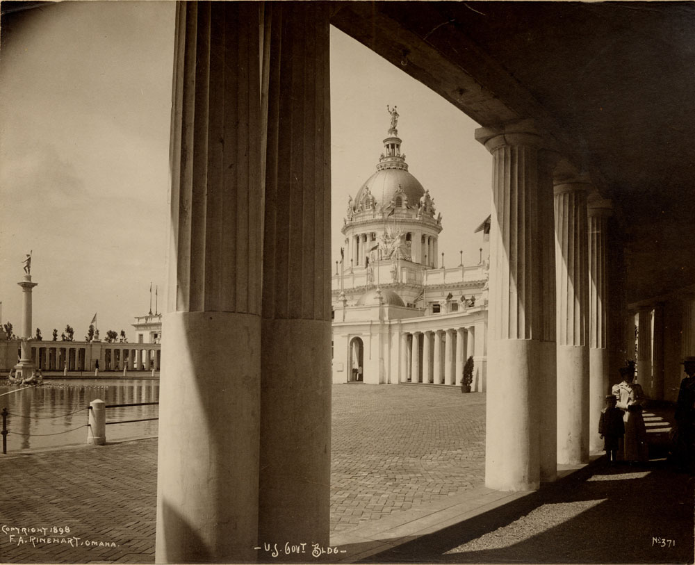View of U.S. Government Building through southwest colonnade. Woman and child standing under portico. Fountain of Neptune visible. Fountain turned off.