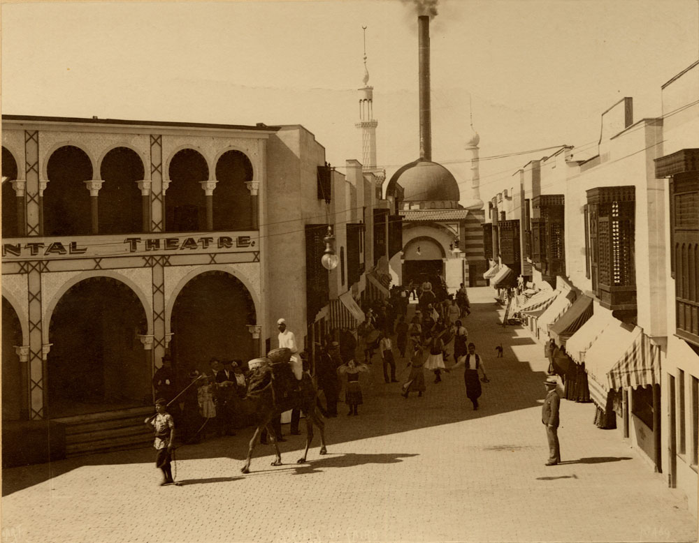 Performers dance and lead camel through Streets of Cairo, in front of Oriental Theater.