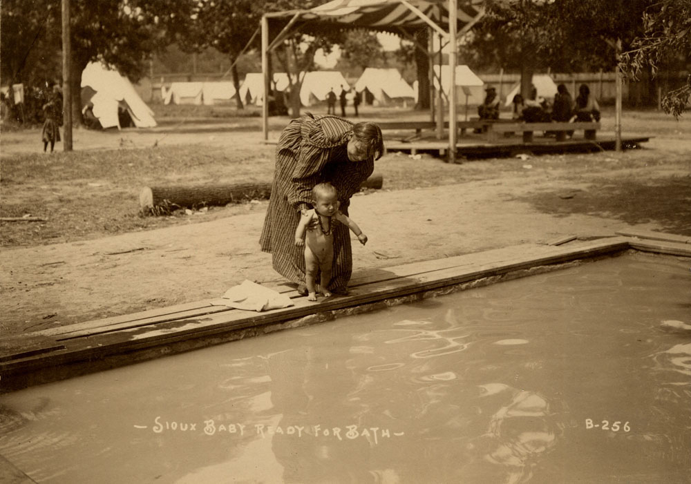 Indian Congress Participants. Sioux Delgates. Woman about to give infant a bath.