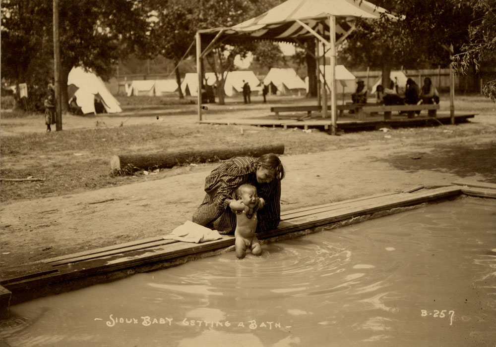 Indian Congress Participants. Sioux Delgates. Woman giving infant a bath.