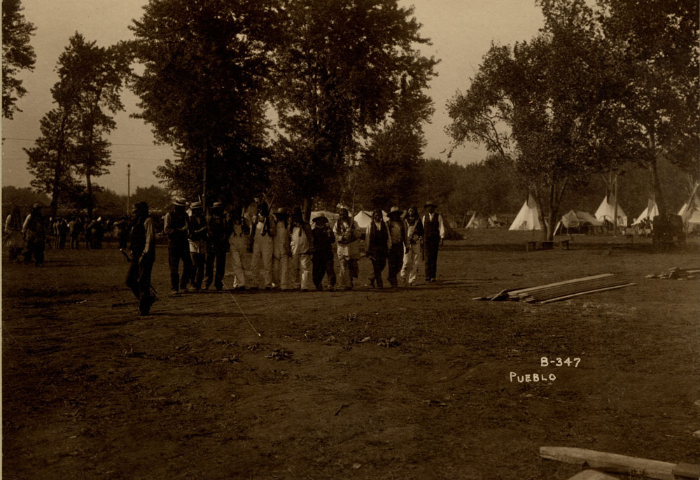 Pueblo delegates of the Indian Congress. Encampment with teepes and wigwams in background.