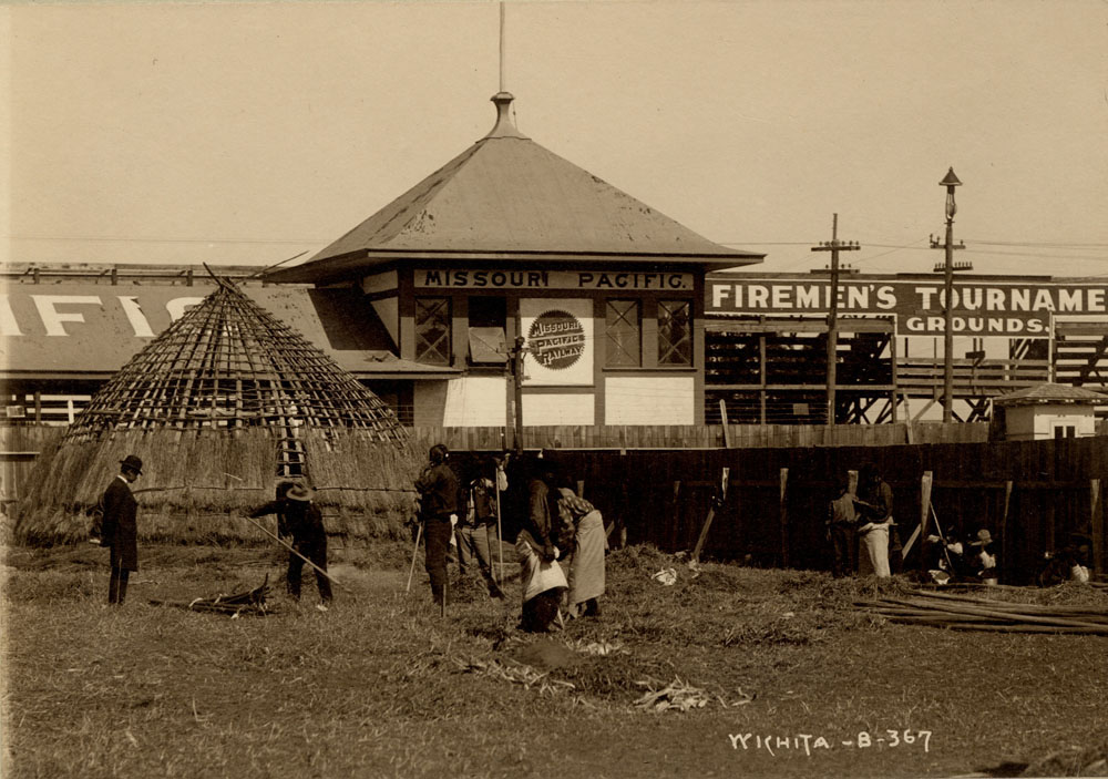 Wichita Delegates of the Indian Congress building Wigwam. Missouri Pacific Railroad stattion in background.