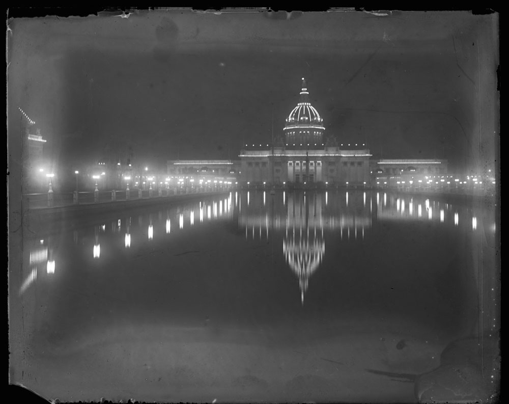 U.S. Government Building at night, looking southwest. Reflection of building in lagoon. Fountain of Neptune turned off. Small portion of Fine Arts Building visible to the southwest.
