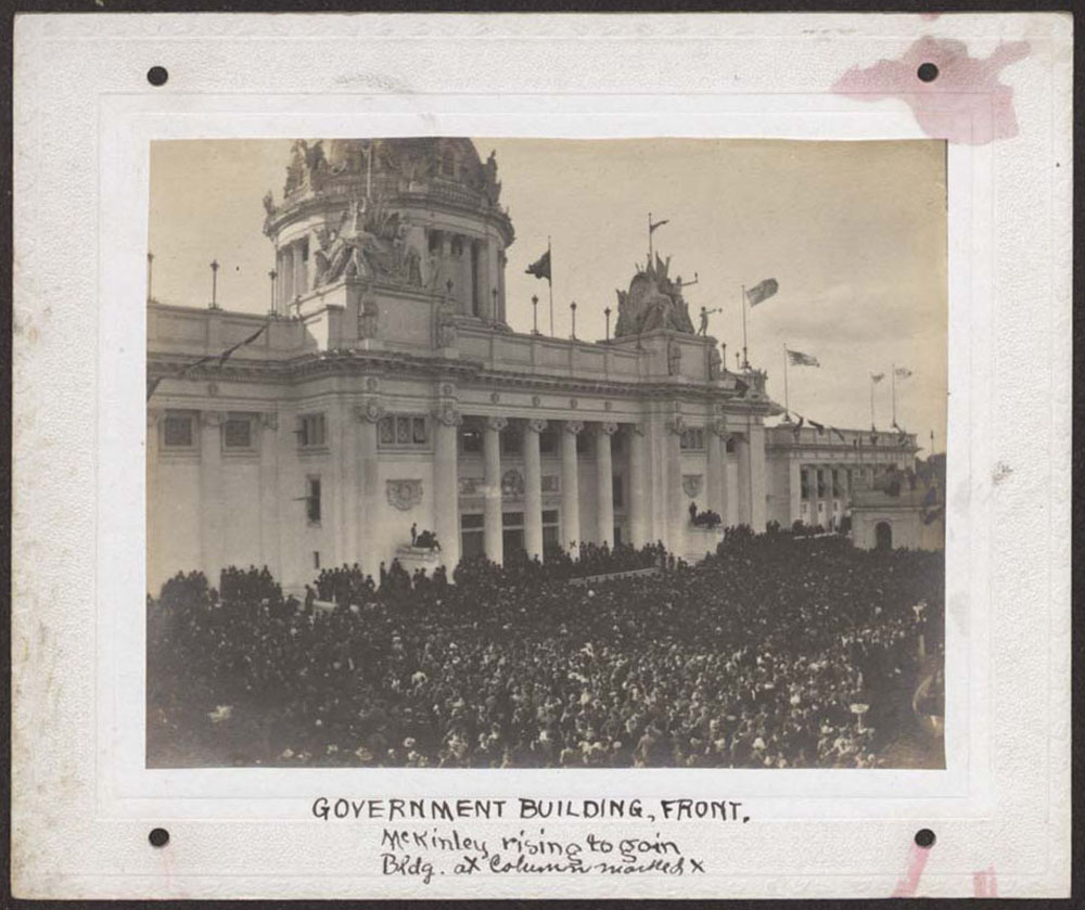 Dense Crowd gathered in front of U.S. Government Building for President William McKinley's Visit. Column marked with "x" indicates where McKinley stands.