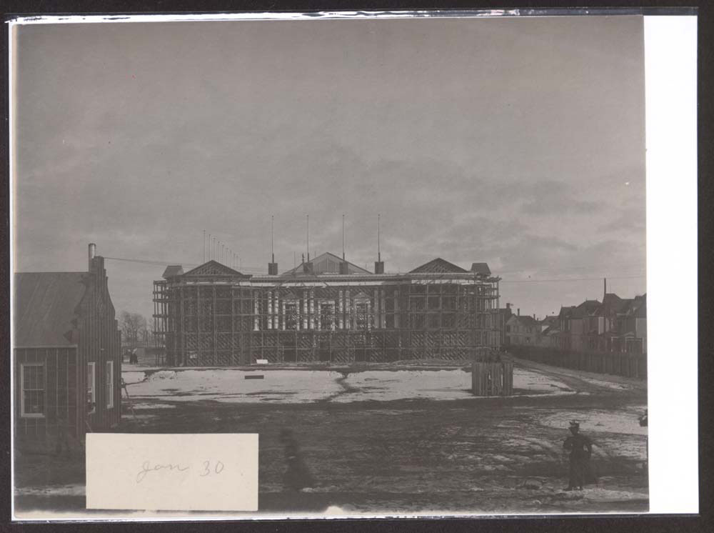 Construction of Liberal Arts Building. Two women walking and standing in foreground. Snow covers the ground.
