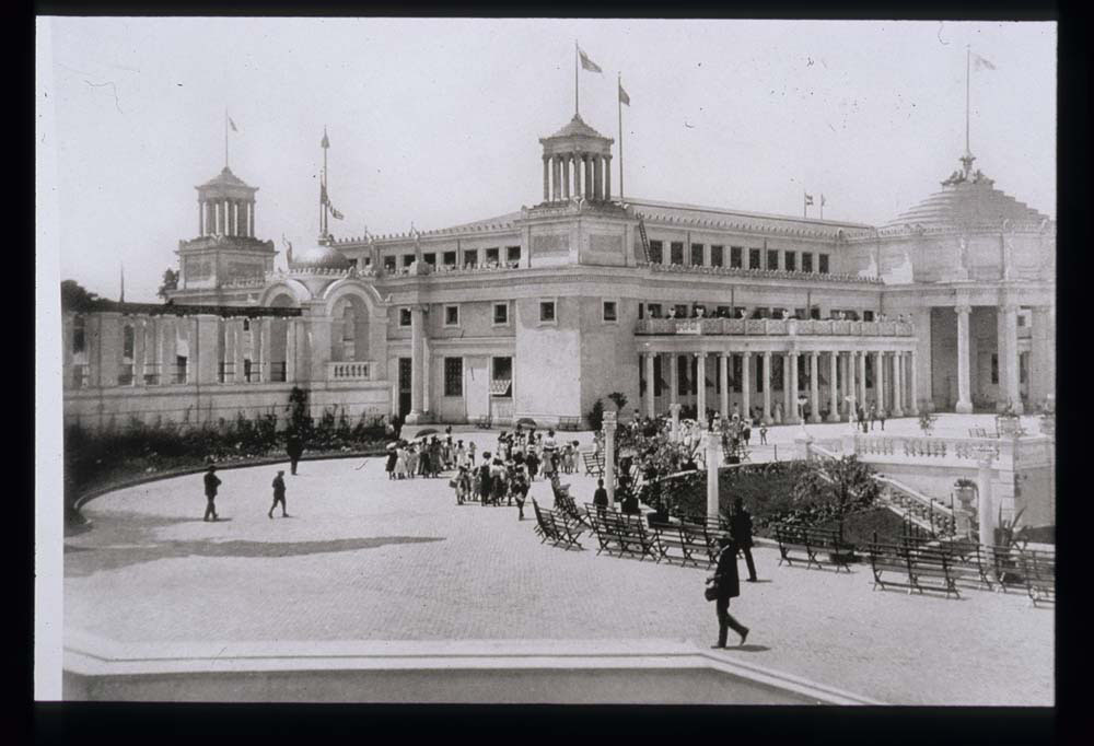 Mines and Mining Building and colonnade. East end of lagoon with garden and benches visible. Crowd walking.