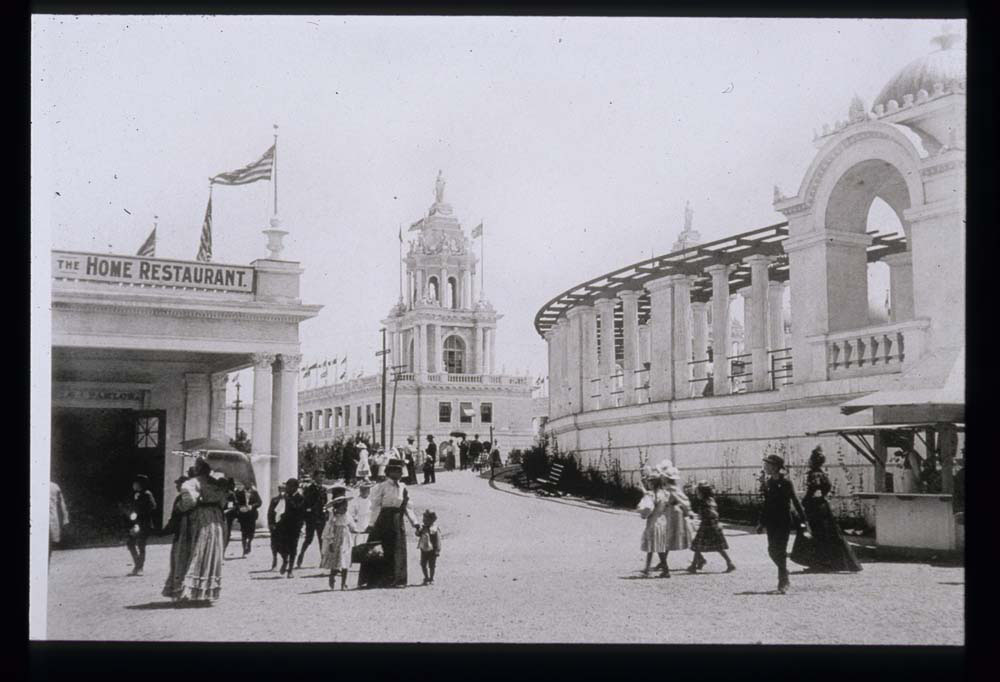 Girls and Boys Building with signage for The Home Restaurant. Twin Tower Restaurant, and Grand Colonnade, looking northeast. Light crowd walking. Concession stand to the east.